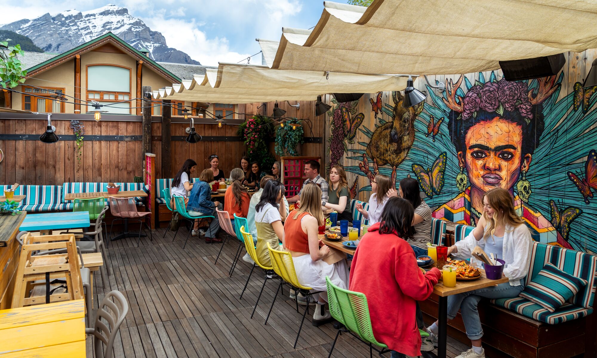 A group of people on a rooftop patio, one of th best things to do in Banff in June