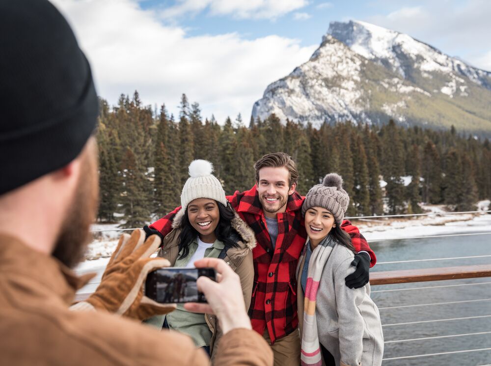 Group of friends taking photos on the Banff Pedestrian Bridge in the spring