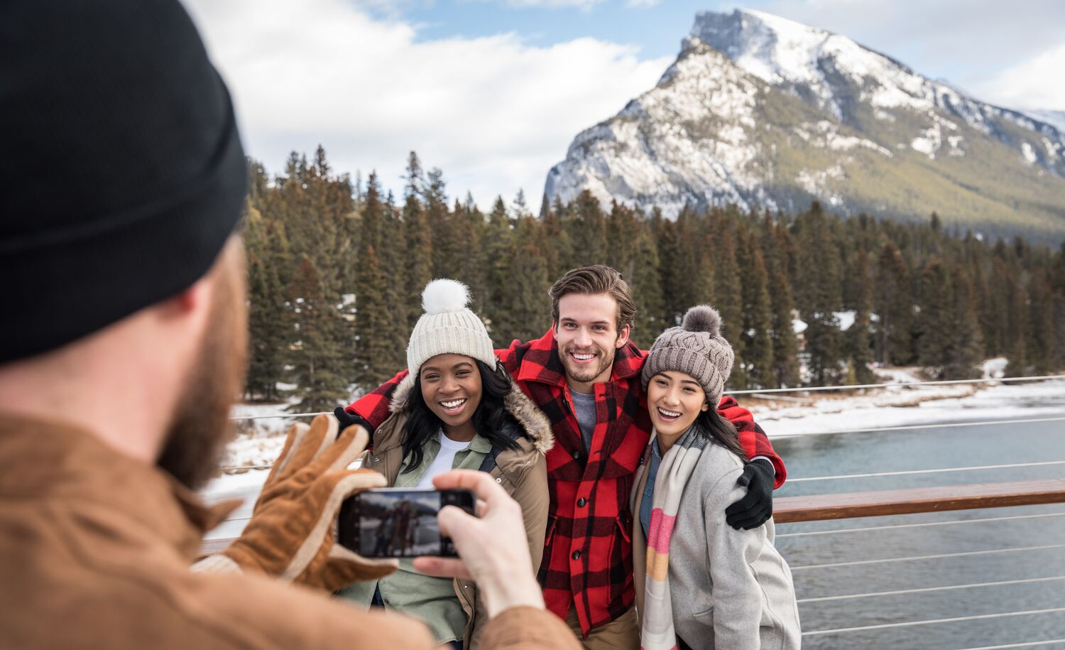 Group of friends taking photos on the Banff Pedestrian Bridge in the spring