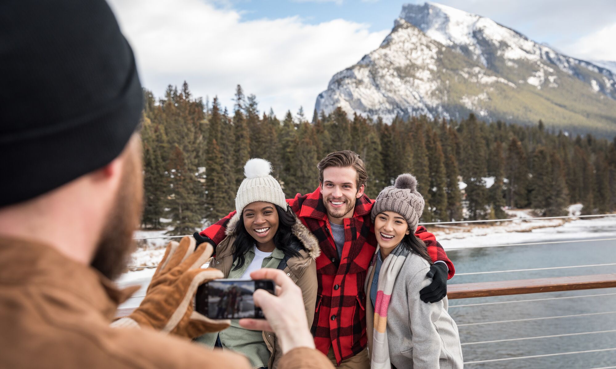 Group of friends taking photos on the Banff Pedestrian Bridge in the spring