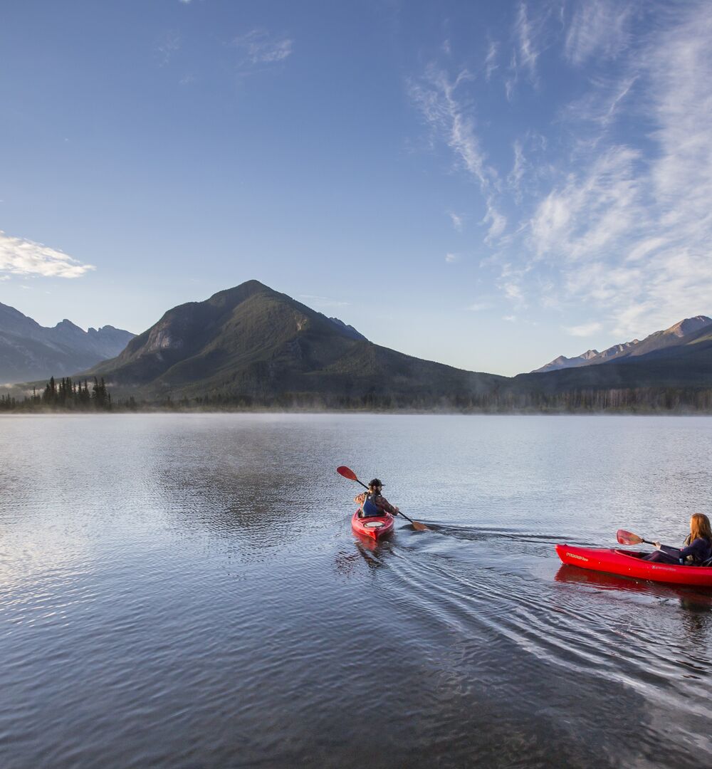 Two people paddling on Vermillion Lakes early in the morning in Banff National Park.