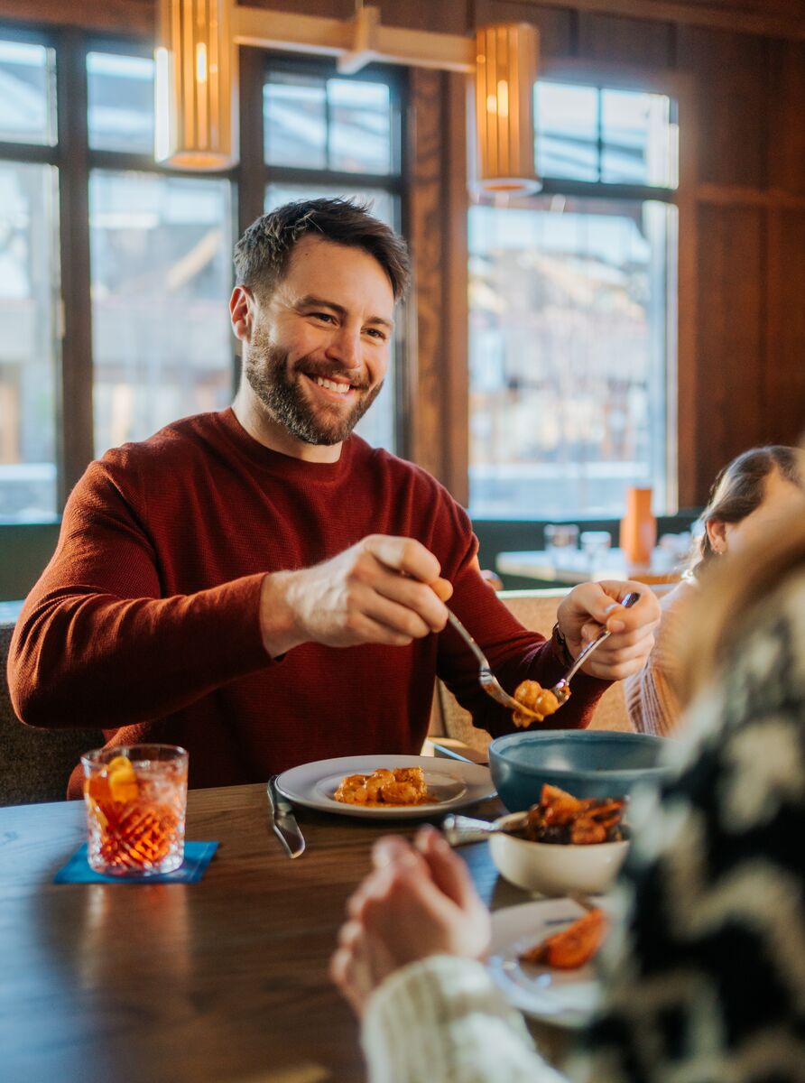 A father dishes food onto a plate at Bluebird in Banff.