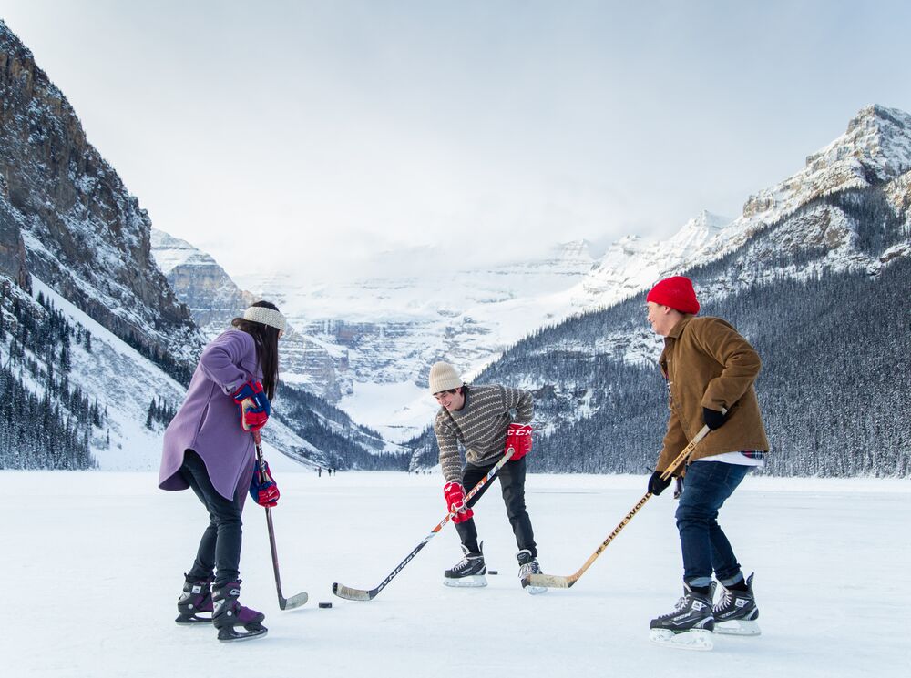 Two friends enjoy a winter walk around the Lake Louise lakeshore in Banff National Park