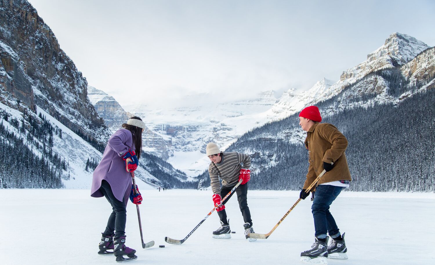 Two friends enjoy a winter walk around the Lake Louise lakeshore in Banff National Park