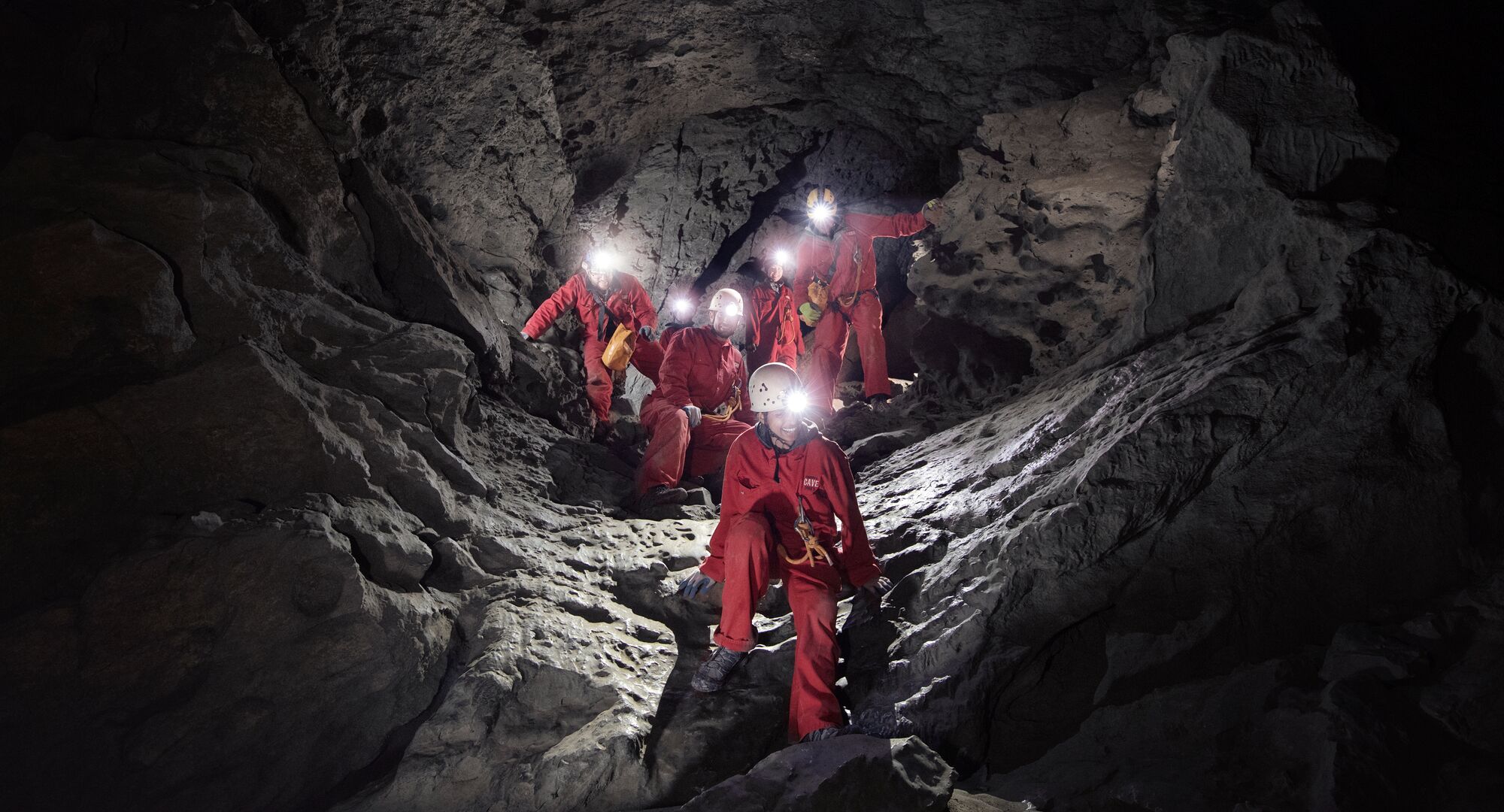Group of people with head torches on deep in a cave on guided cave tour with Canmore Cave Tours