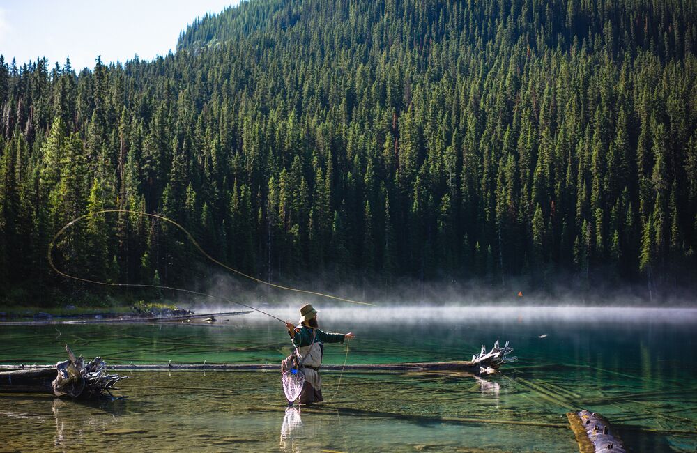 Man fishing in Marvel Lake in the backcountry of Banff National Park
