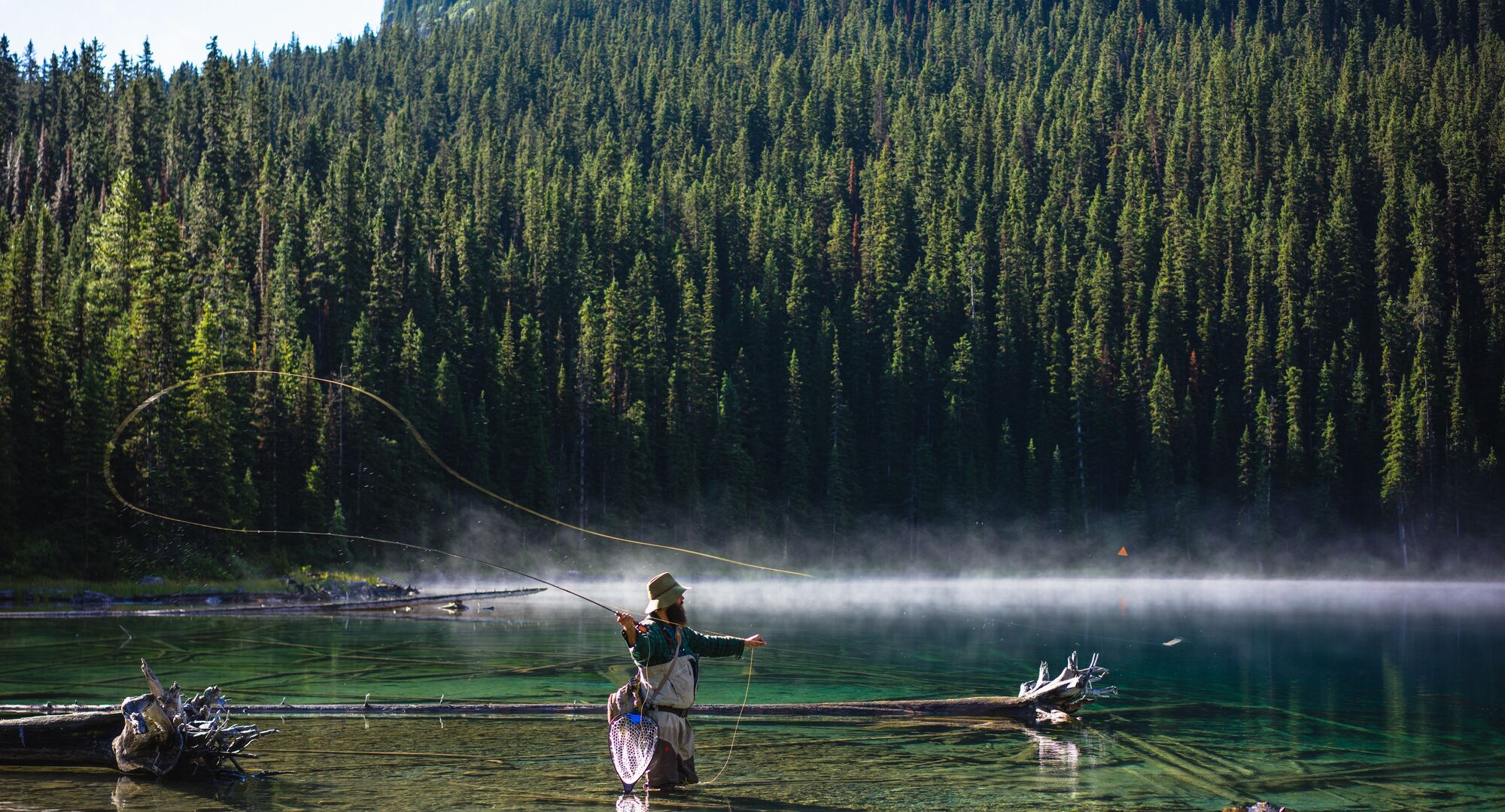 Man fishing in Marvel Lake in the backcountry of Banff National Park