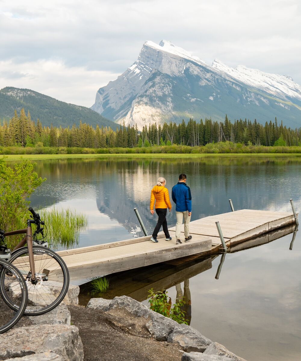 Two friends explore Vermilion Lakes after a bike ride in Banff National Park