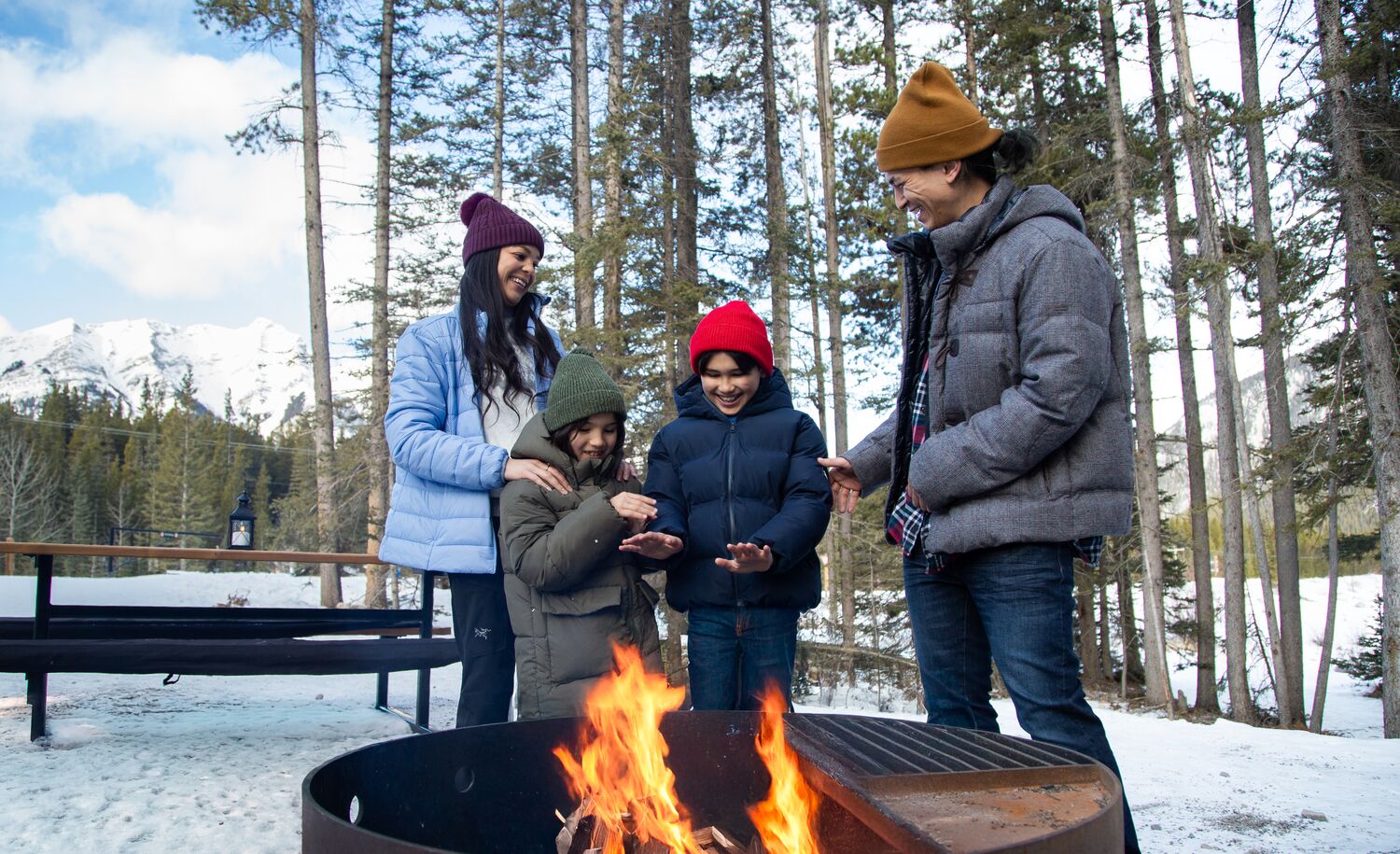 A family warming up by the fire after a winter adventure in Banff National Park