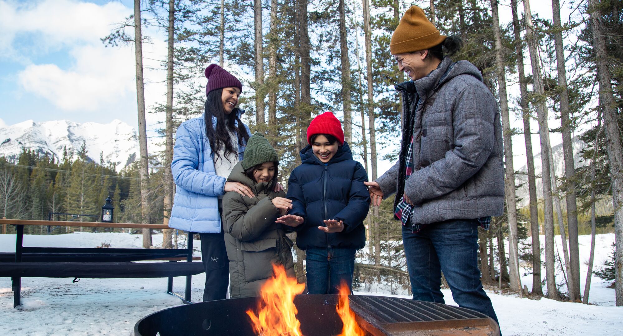 A family warming up by the fire after a winter adventure in Banff National Park