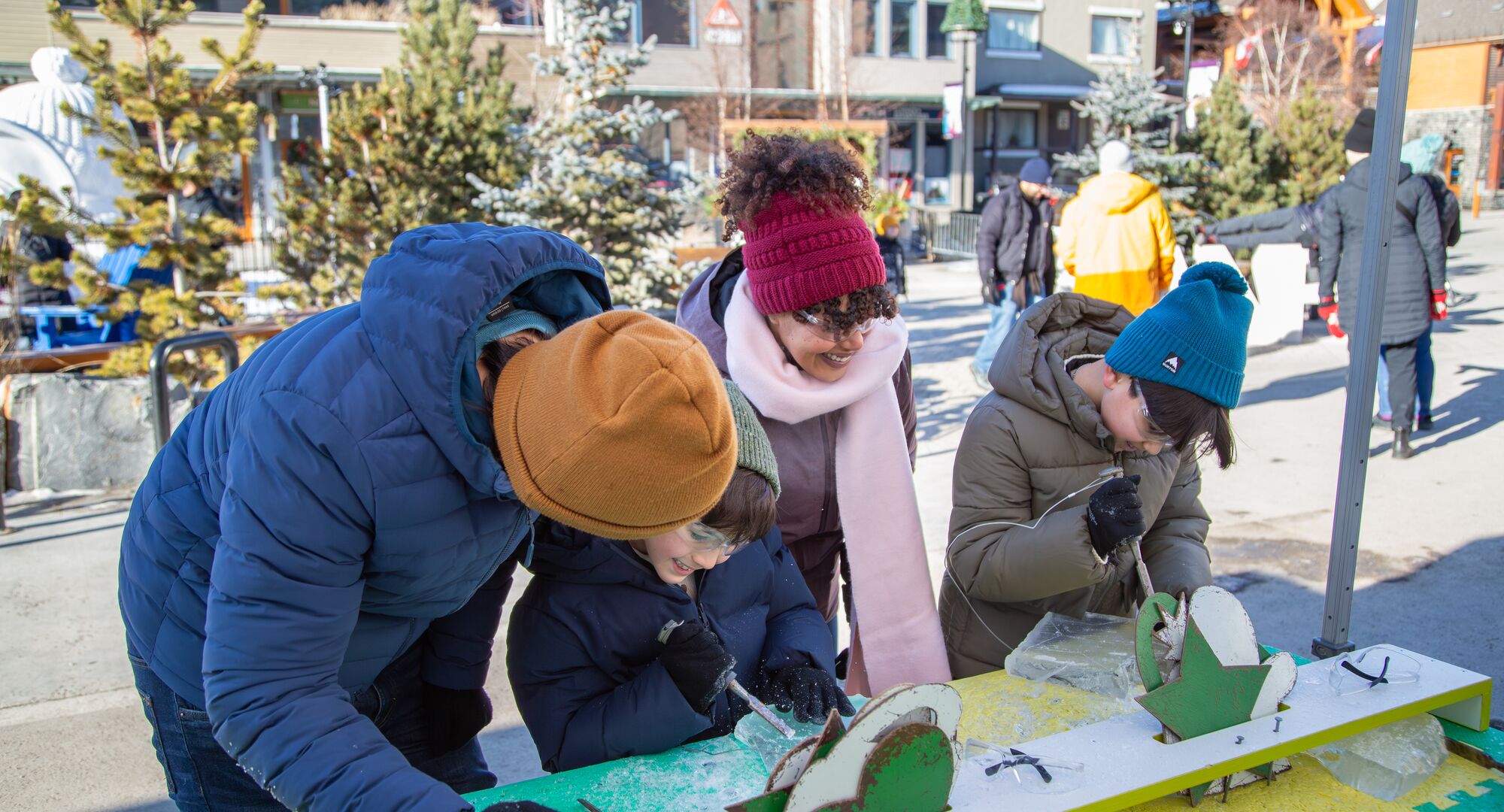 A family trying out ice carving at the Weekend of Wonder at SnowDays in Banff