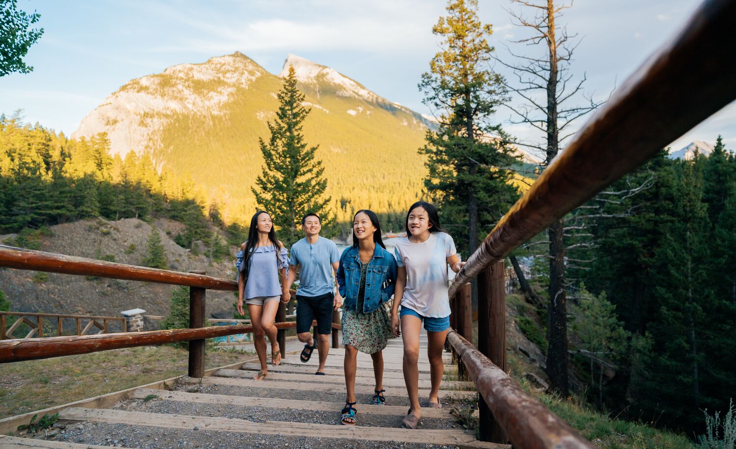 A family of four walking along the Bow River, a popular thing to do in Banff National Park