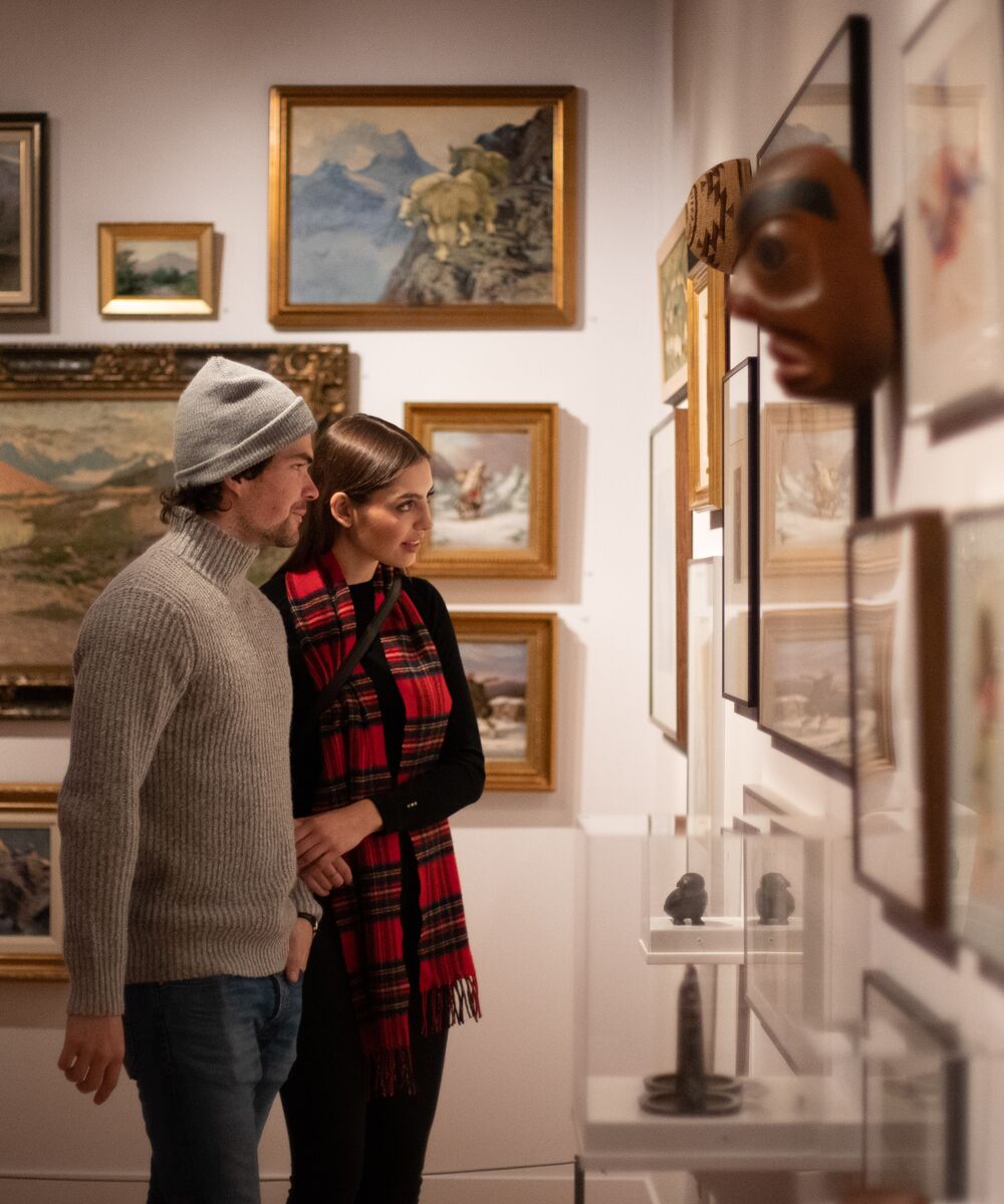 Two people exploring a gallery exhibit in Banff.