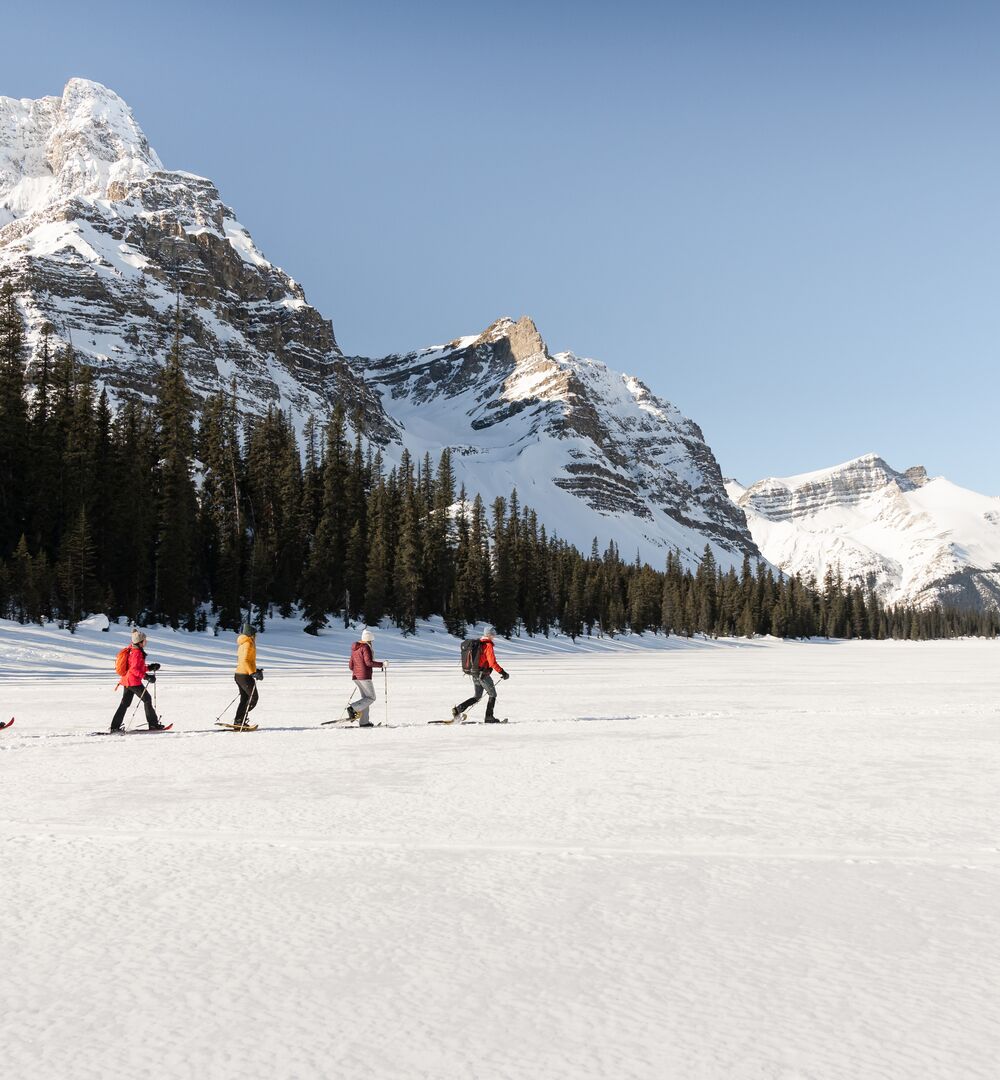 Group snowshoeing on a frozen lake in Banff National Park