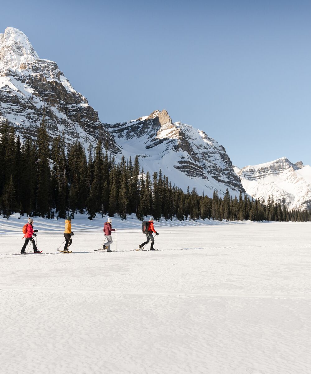 Group snowshoeing on a frozen lake in Banff National Park