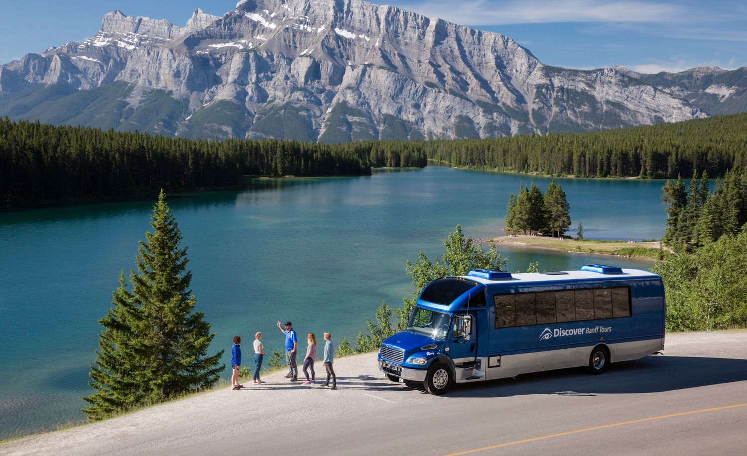 People on a sightseeing tour at Two Jack Lake, a popular thing to do in Banff in June