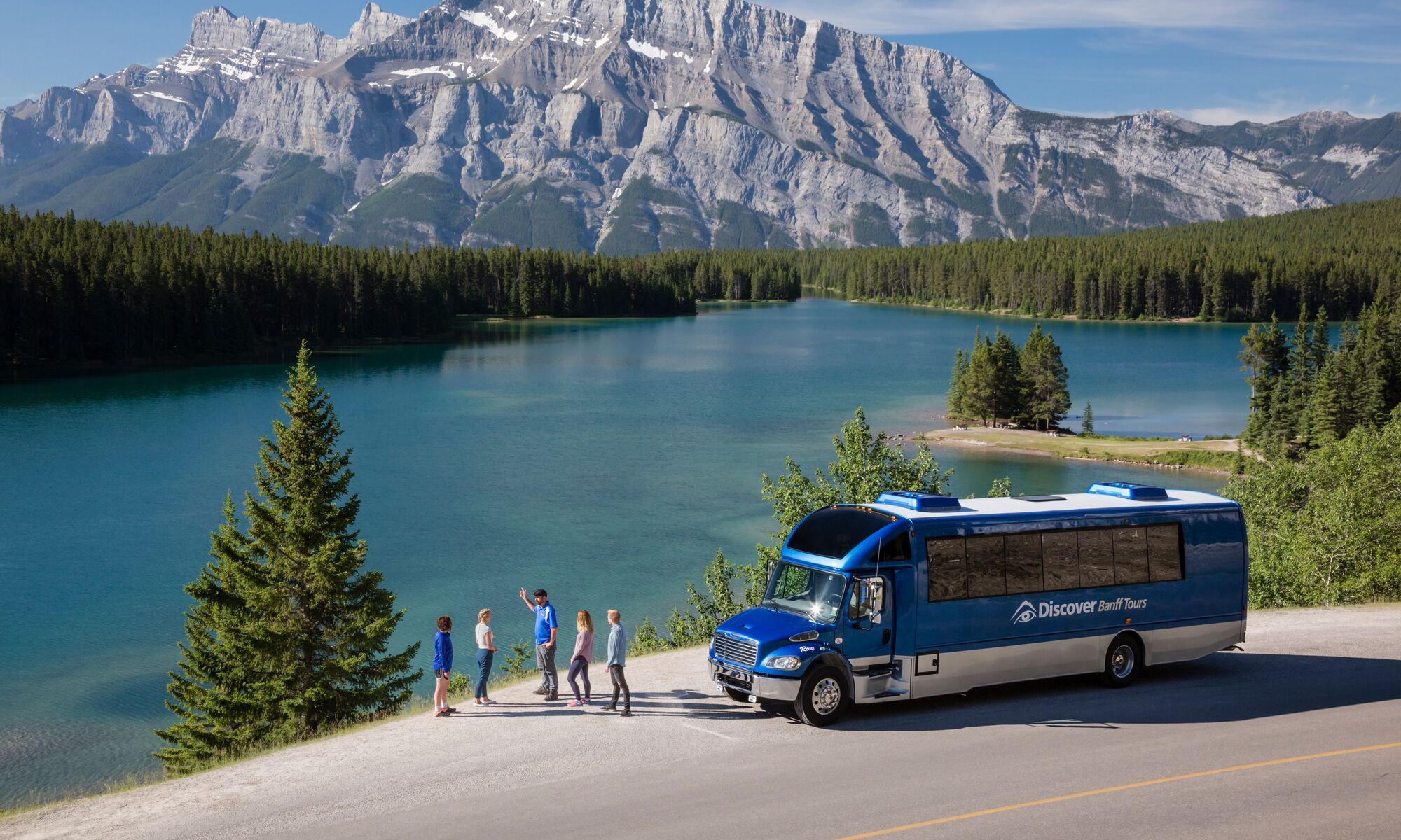 People on a sightseeing tour at Two Jack Lake, a popular thing to do in Banff in June