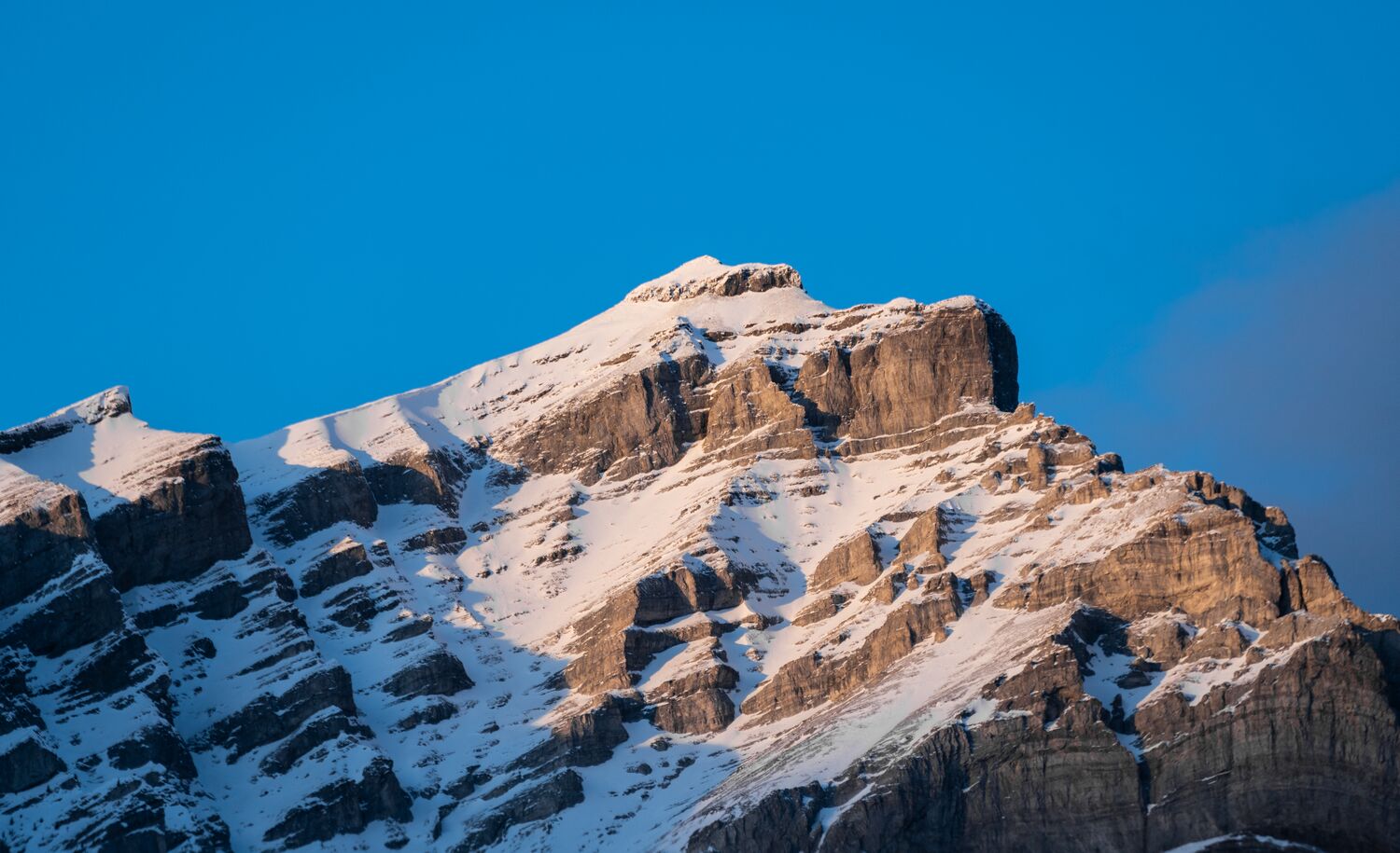 The peak of Cascade Mountain as touched by the light at sunrise in Banff National Park.