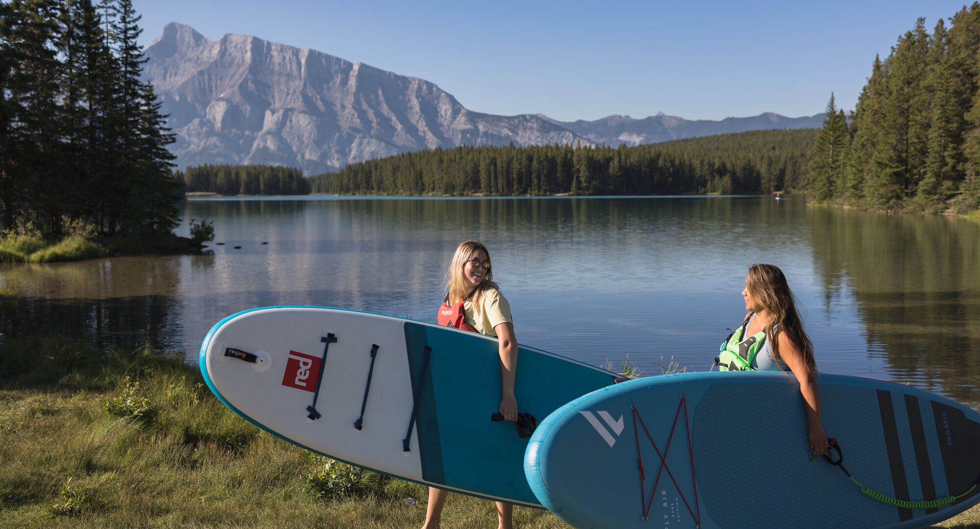 Two people taking a SUP lesson at Two Jack Lake