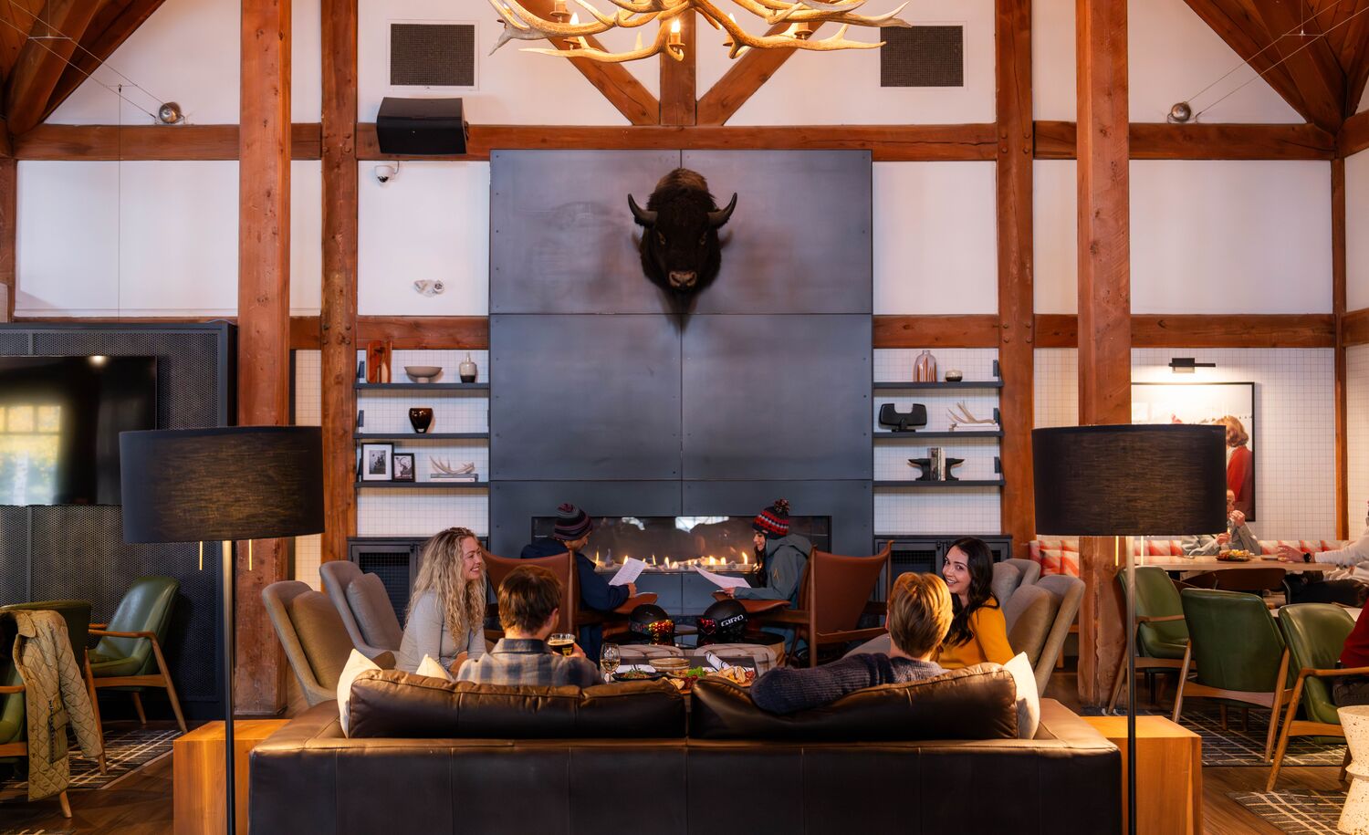 Interior image of the Prow featuring a fireplace and people sitting around tables at the restaurant in Banff, Canada.