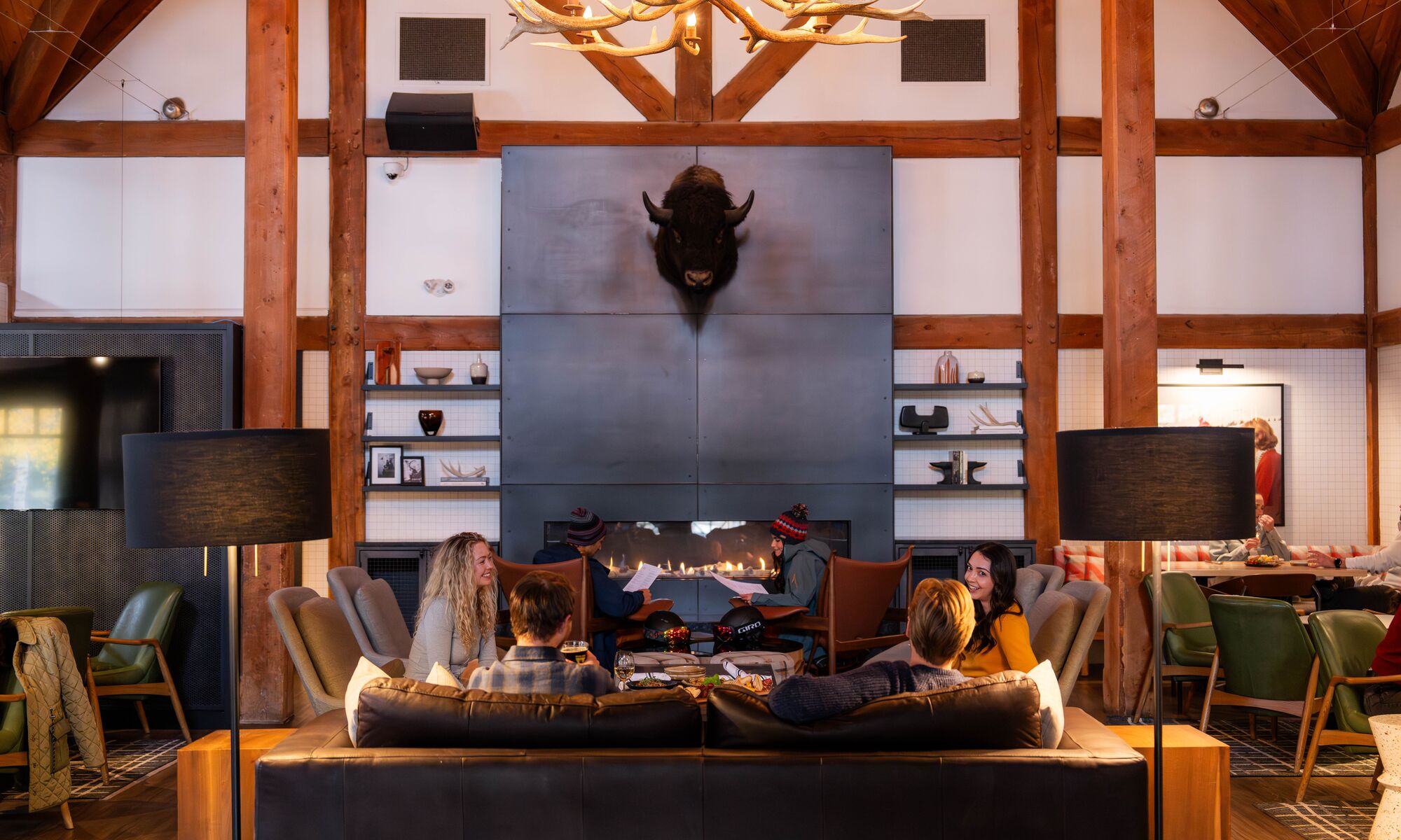 Interior image of the Prow featuring a fireplace and people sitting around tables at the restaurant in Banff, Canada.