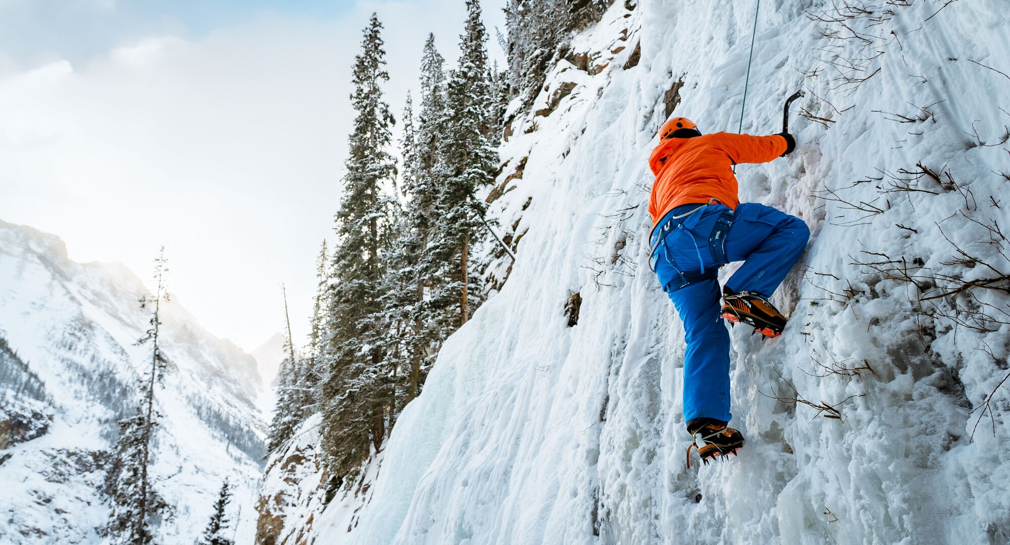 An ice climber travels up a frozen waterfall in Banff National Park
