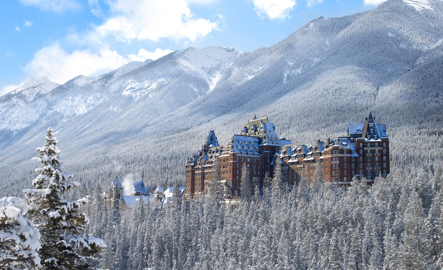 The Fairmont Banff Springs Hotel in Banff rises above frosty and snowy trees in the depths of winter in Banff National Park.