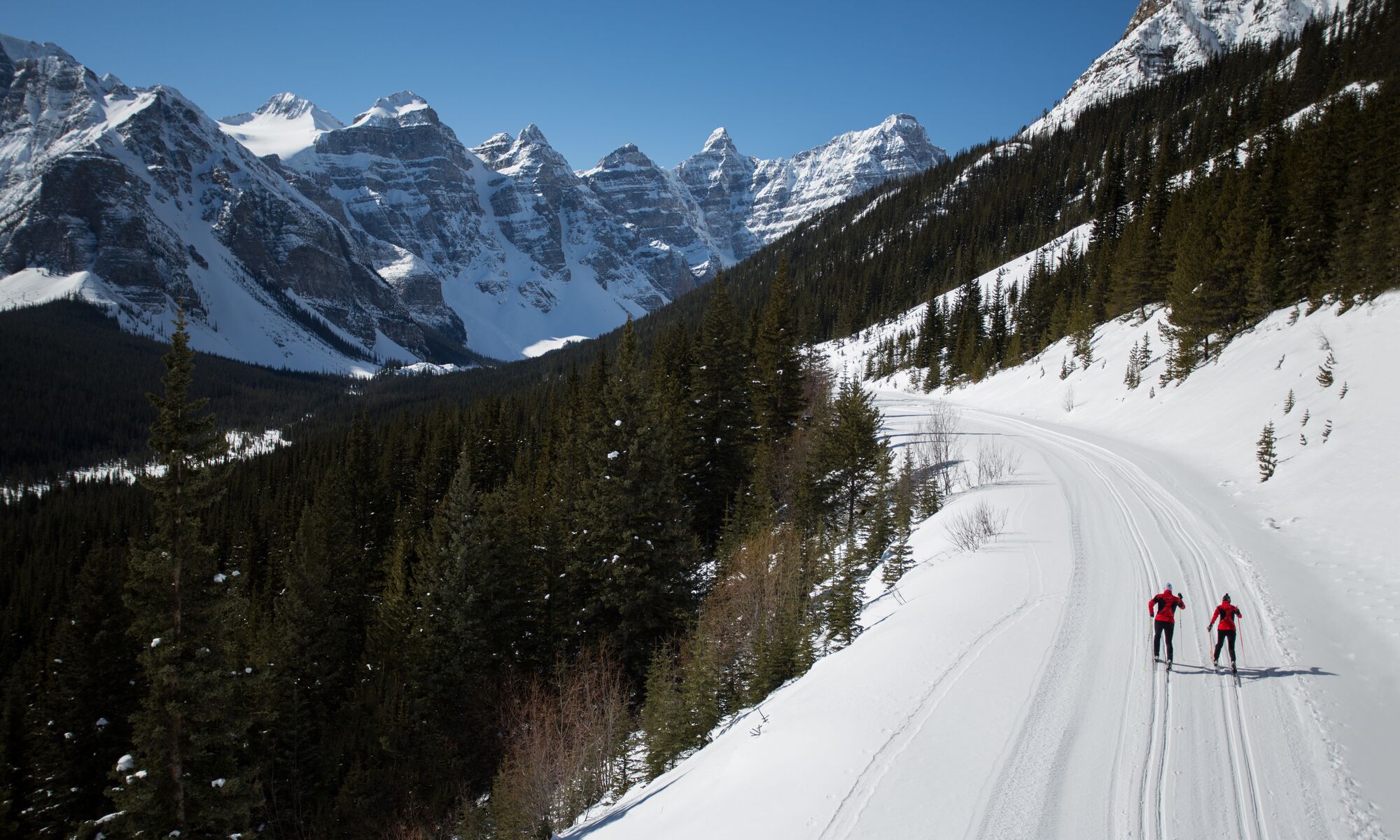 Two people cross country ski on the Moraine Lake Road in Banff National Park.