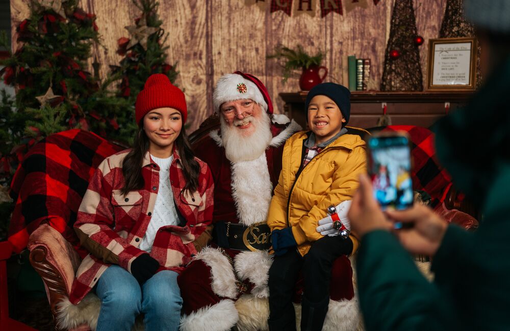 Kids sit with Santa at the Banff Christmas Market.