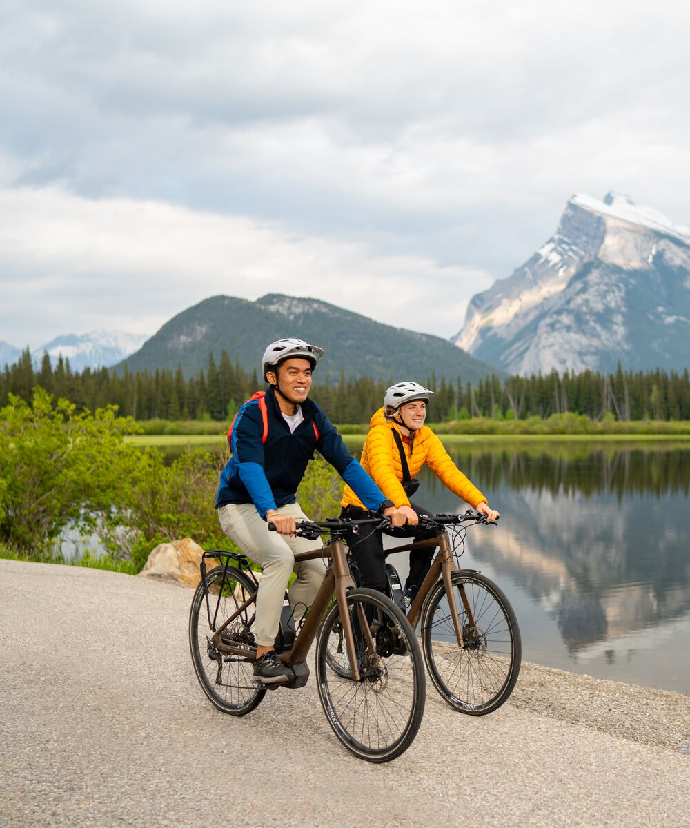 Two people biking on Vermilion Lake Drive in Banff National Park