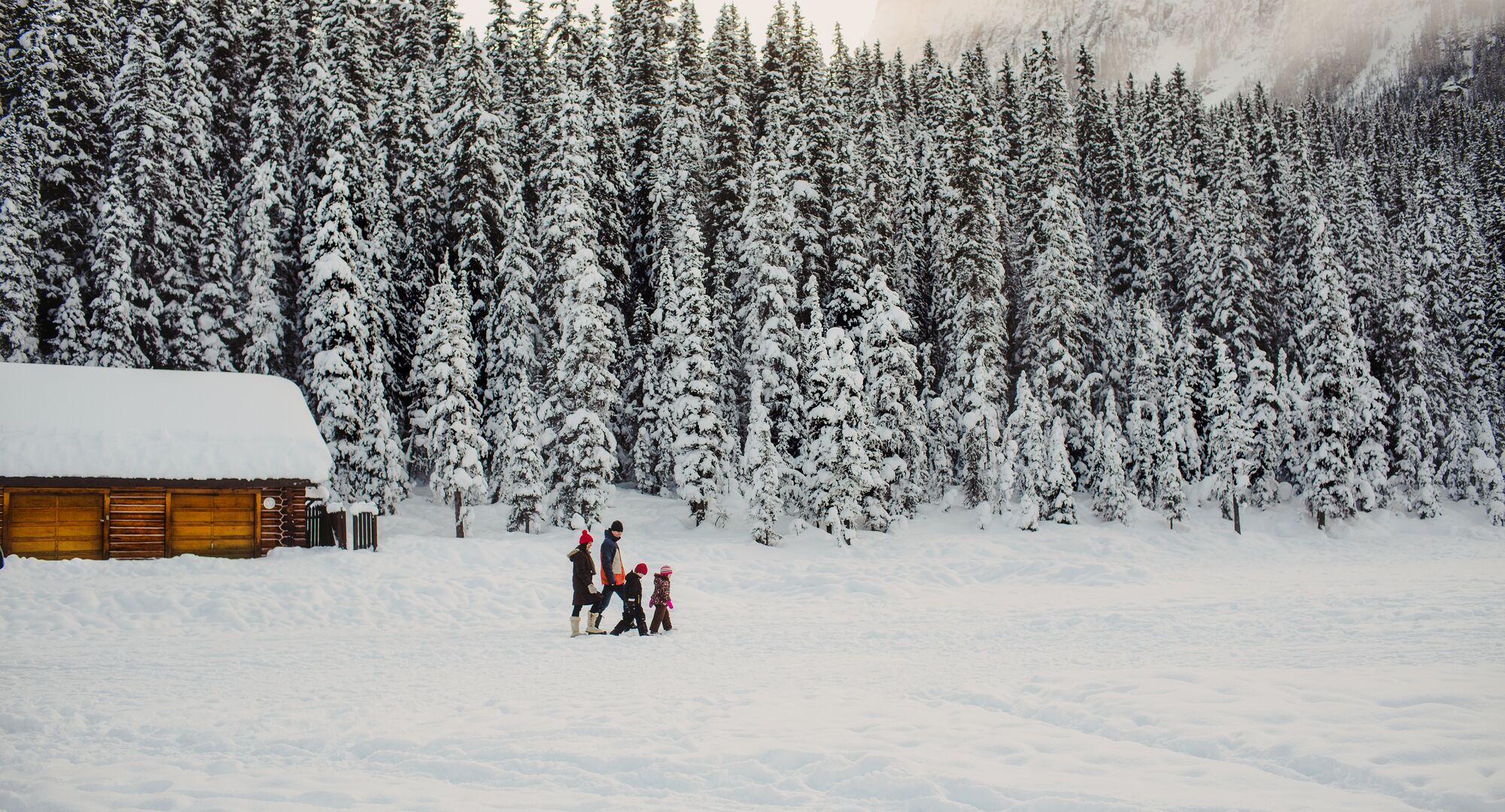 Family walking across a Lake Louise in the winter