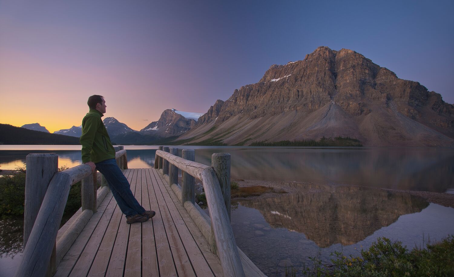 Lukas stands on a bridge at Bow Lake