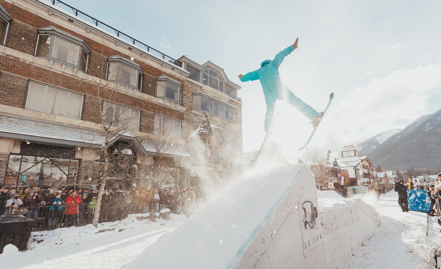 A horse pulls a trick skier over a snow jump in a Skijoring event on Banff Ave in Banff, Canada.