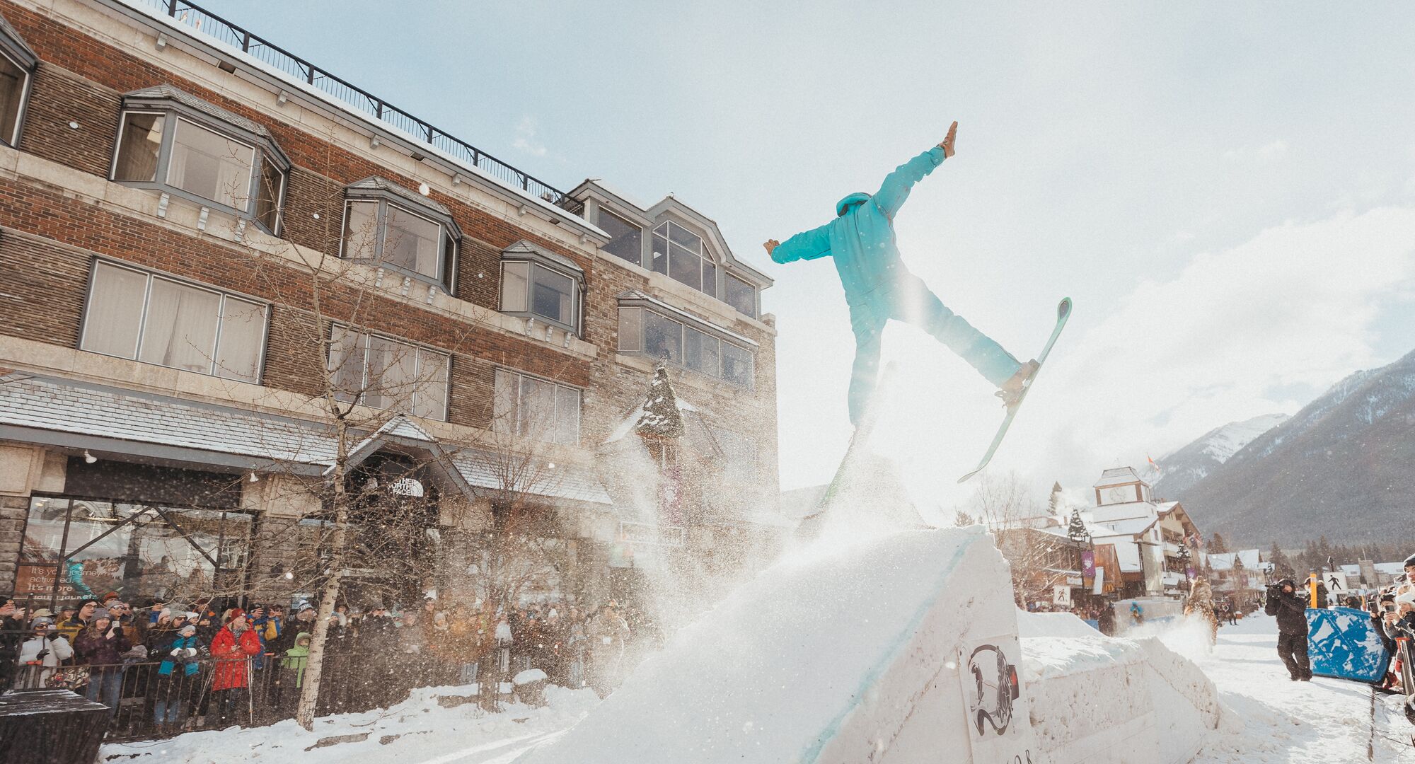 A horse pulls a trick skier over a snow jump in a Skijoring event on Banff Ave in Banff, Canada.
