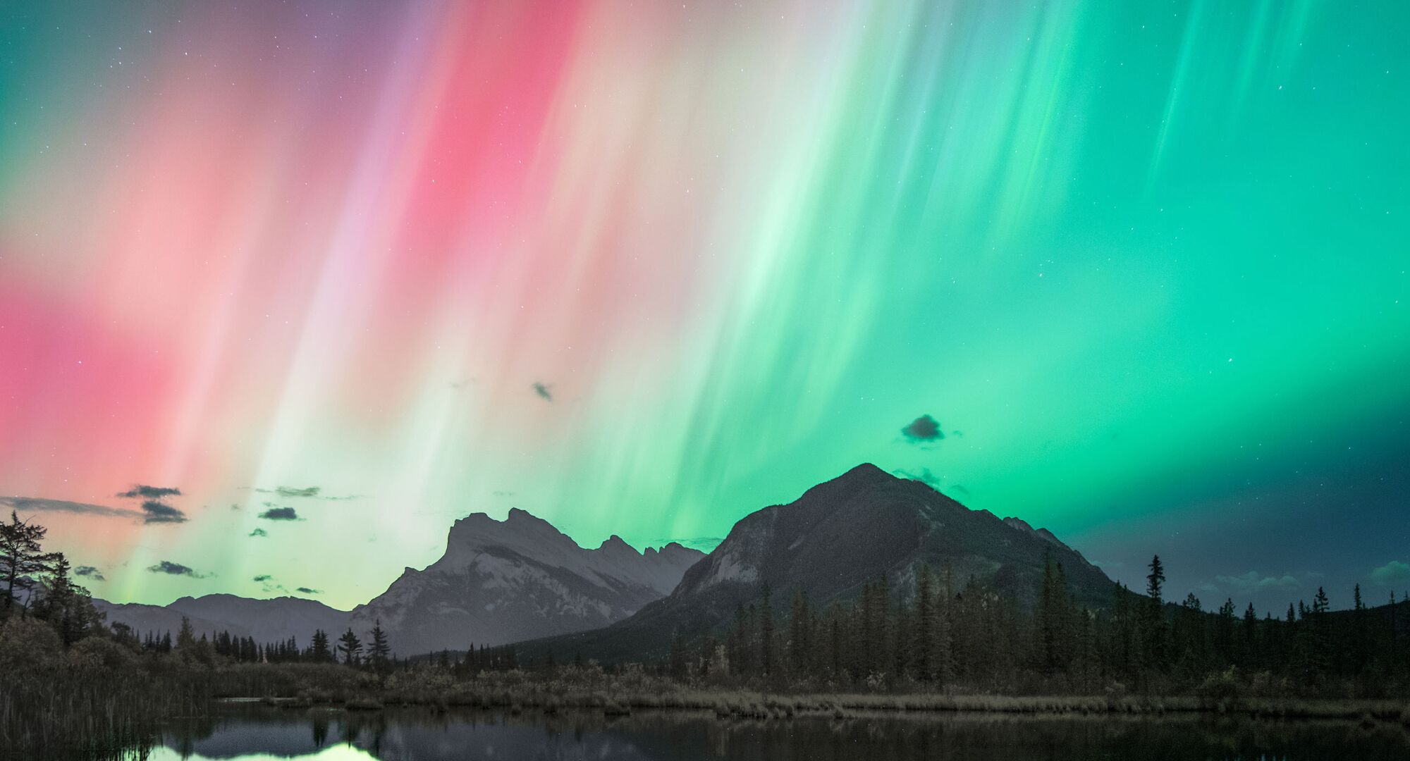 The aurora dances overtop of Mount Rundle as seen from Vermilion Lakes in Banff National Park.