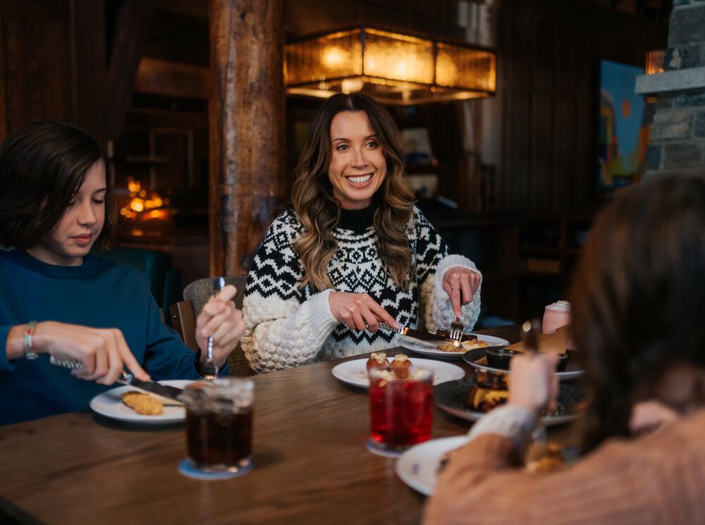Group of friends sat around a table enjoying a charcuterie board in Banff