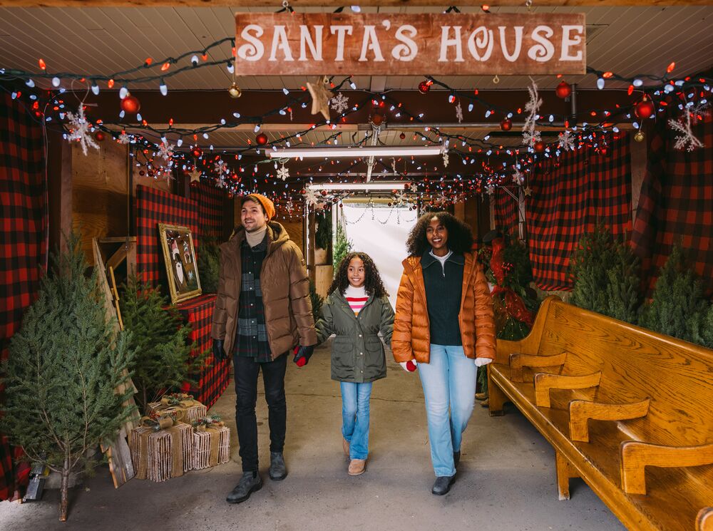 A family walk out of Santa's House at the Banff Christmas Market in Banff National Park.