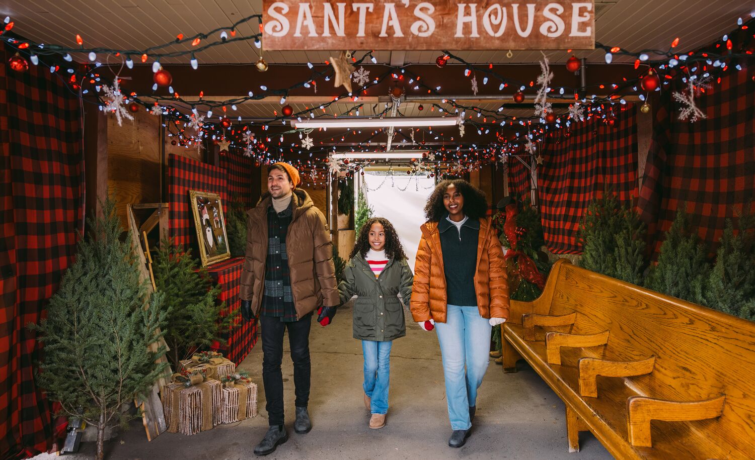 A family walk out of Santa's House at the Banff Christmas Market in Banff National Park.