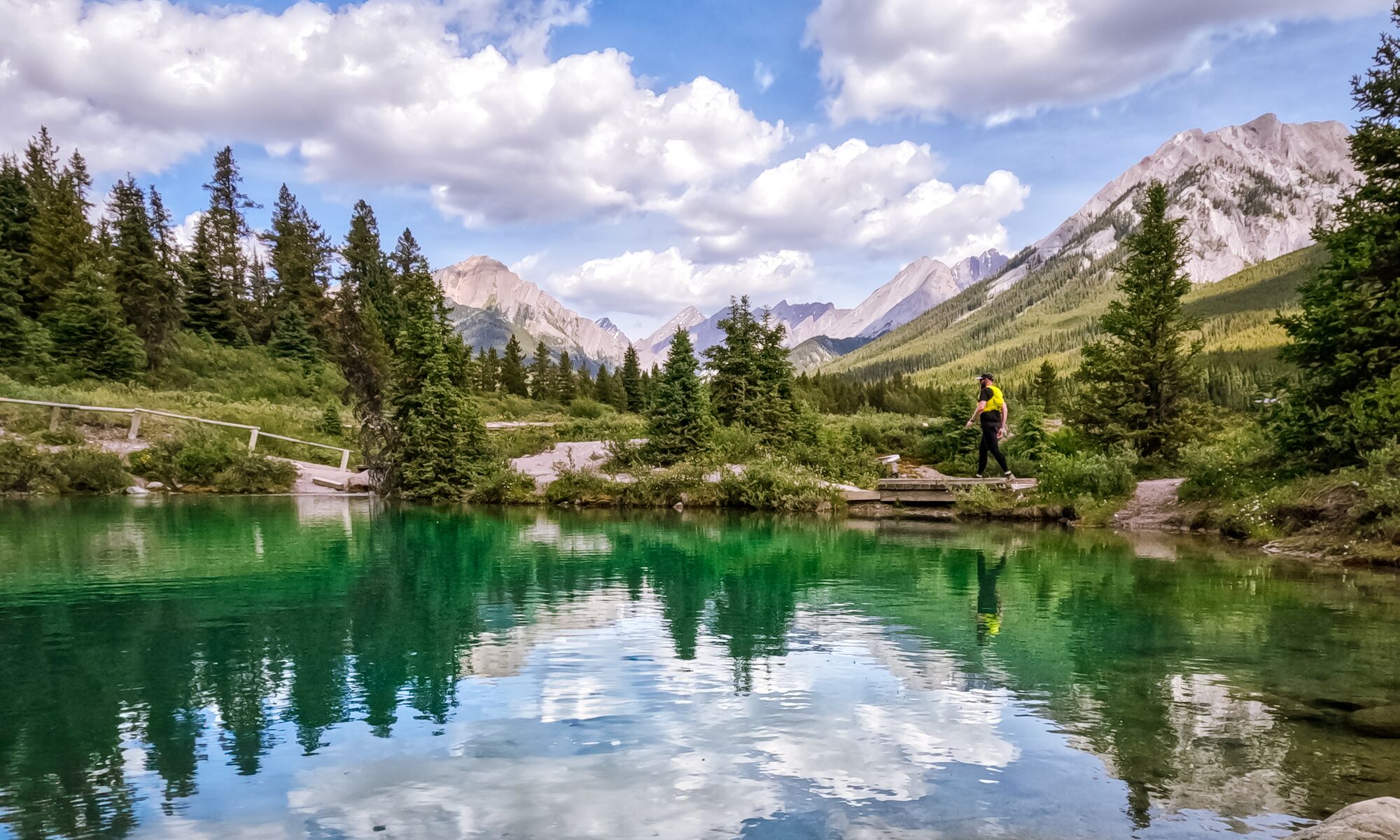 A trail runner walks across a bridge at the Ink Pots in Banff National Park.