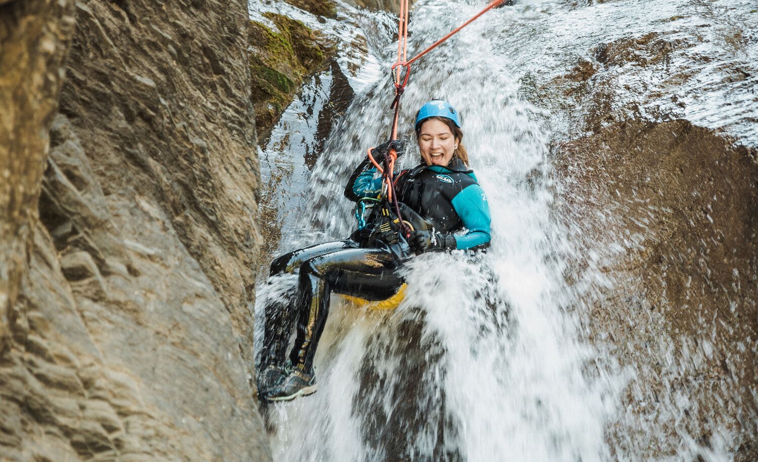 A women repeling down a canyon waterfall with Banff Canyoning, a popular thing to do in Banff in July