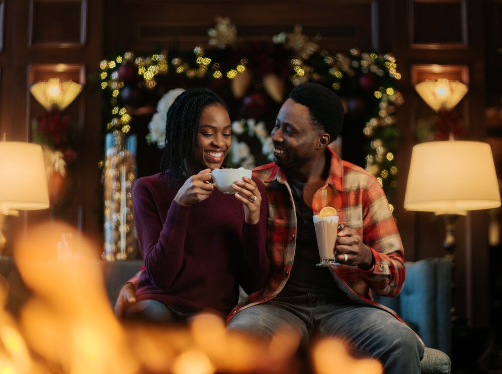 A couple enjoying hot chocolates for the hot chocolate trail at the Rimrock Resort in Banff