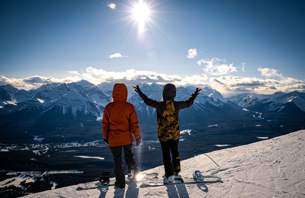 Two snowboarders stop to enjoy the views at the Lake Louise Ski Resort in Banff National Park