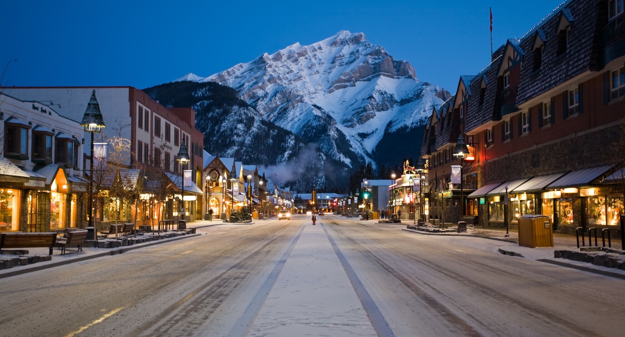 View looking down Banff Avenue in the winter with a snowy Cascade Mountain in the background