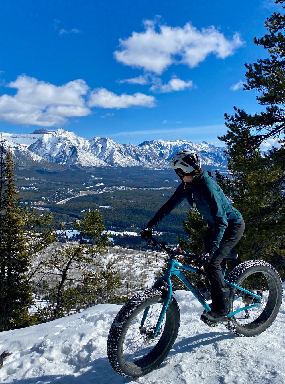A fat biker looks out over a ridge on the Tunnel Mountain trails in winter in Banff National Park.