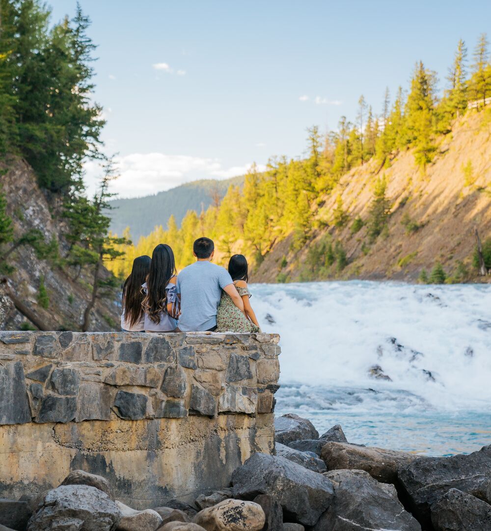 A family of four taking in the views at Bow Falls in the summer