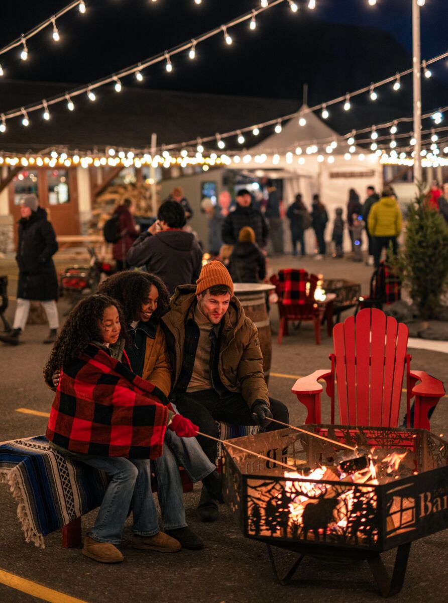 Friends gathering around the fire at the Banff Christmas Market.