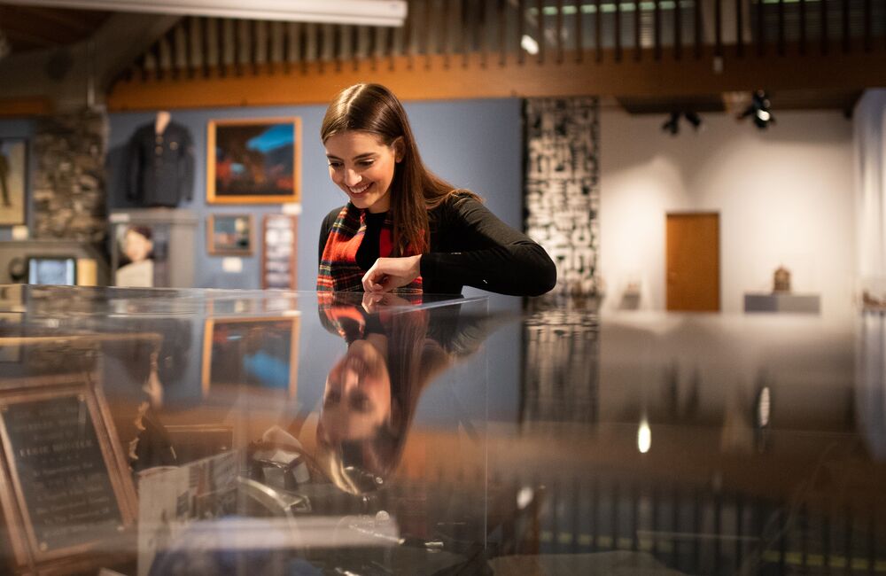 A person looking in a display case at the Whyte Museum of the Canadian Rockies
