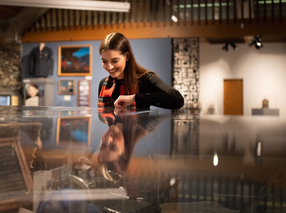A person looking in a display case at the Whyte Museum of the Canadian Rockies