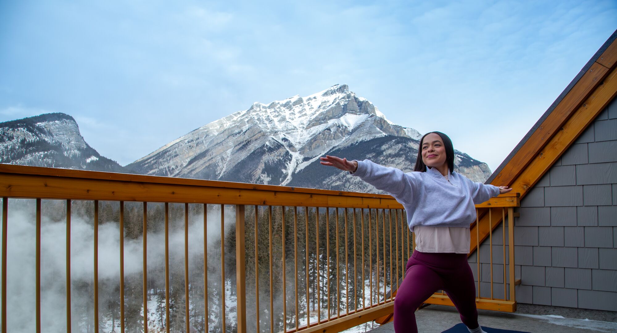A person doing yoga with mountains in the background in Banff National Park