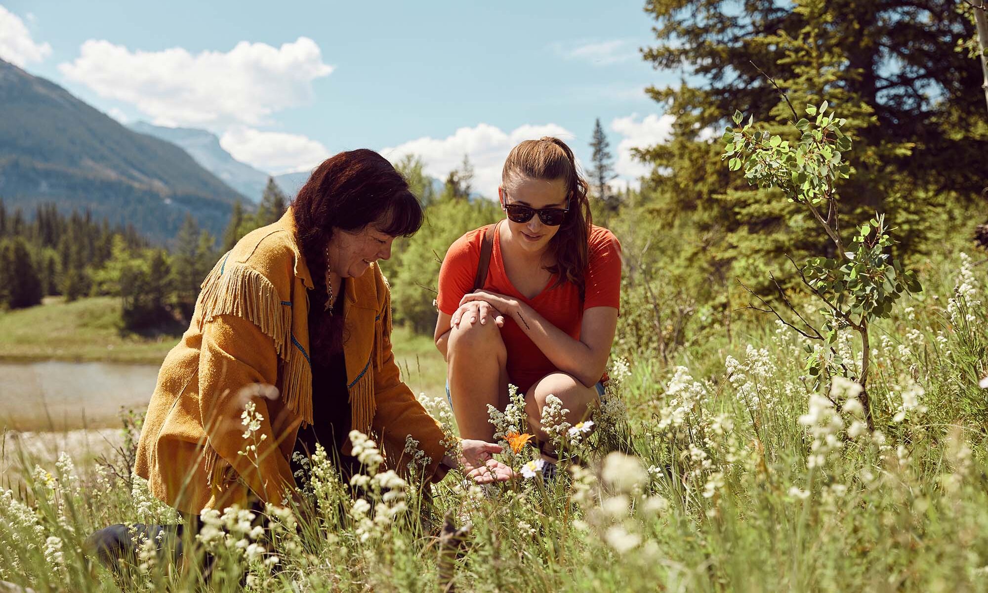 A woman and a guide look at plants during a Medicine Walk.